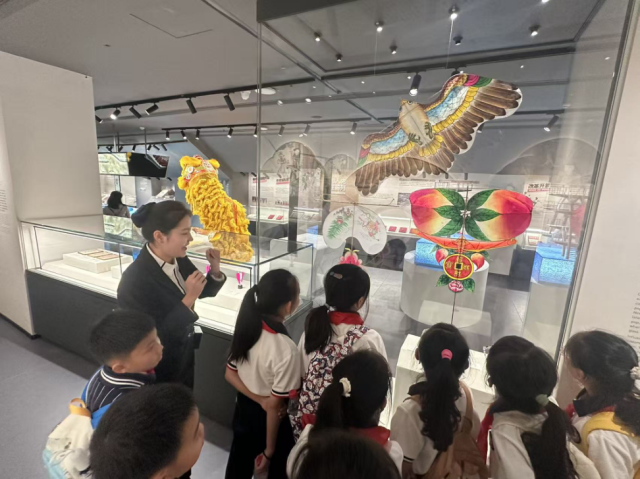 讲解员正在为参观体育博物馆的小学生们介绍阳江风筝